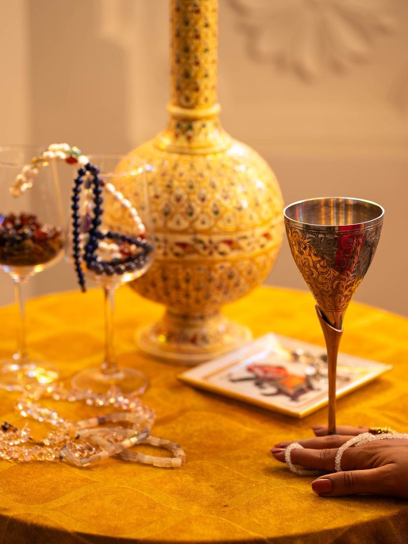 Hand-painted gold vase and goblet on a table